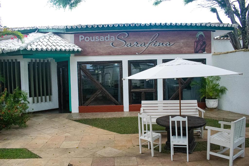 pousada da sarafina ltda في سلفادور: طاولة وكراسي ومظلة أمام مطعم