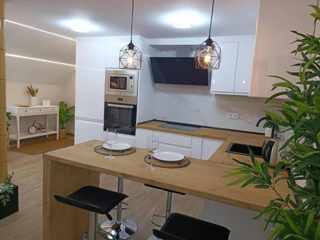 een keuken met een tafel en 2 krukken bij Apartamento RyR in Padrón