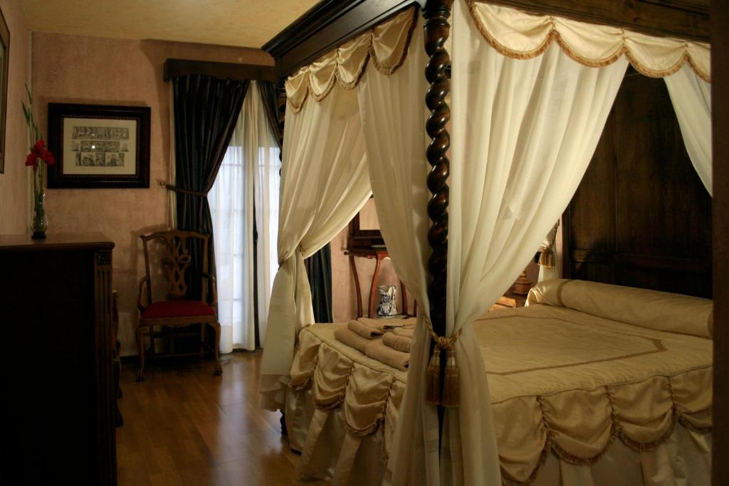 a bedroom with a canopy bed with curtains at La Posada del Hidalgo de Alarcón in Alarcón