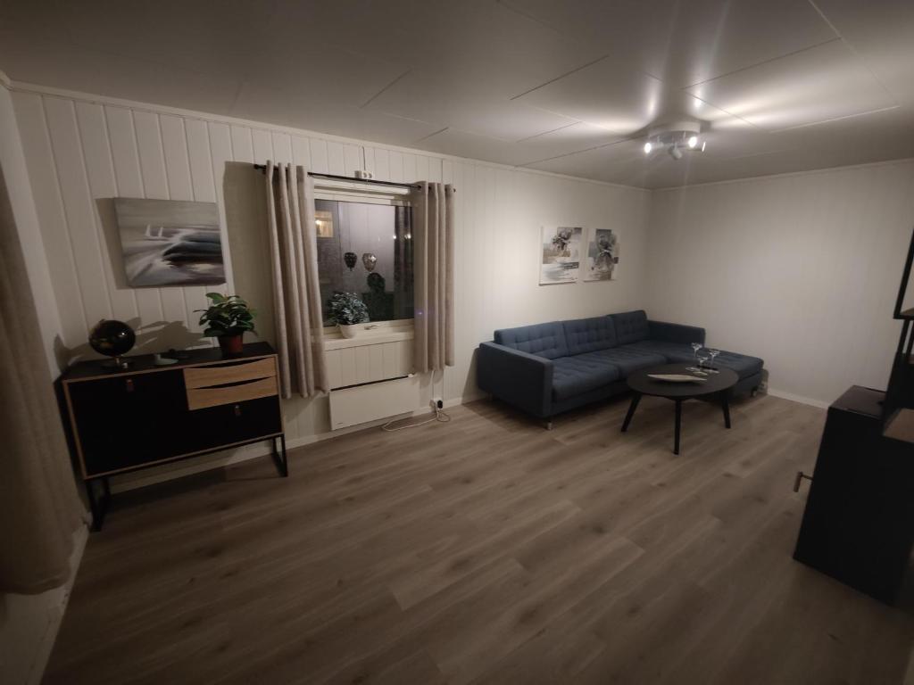 sala de estar con sofá azul y mesa en Vardø accommodation - white house, en Vardø