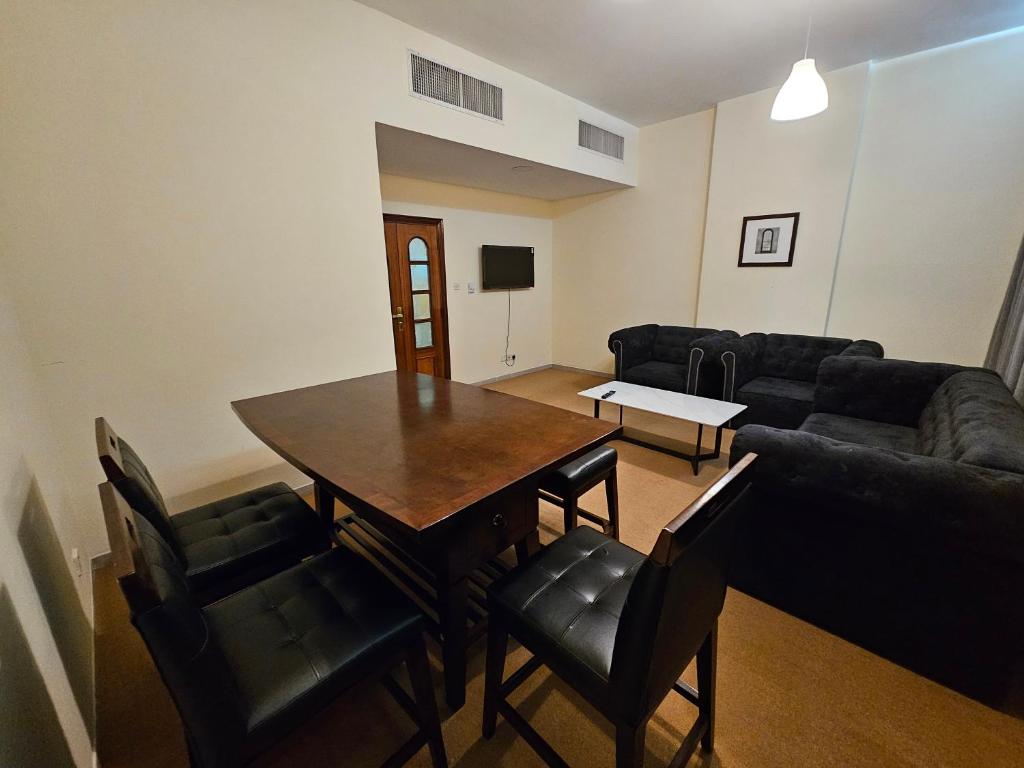 sala de estar con mesa, sillas y sofá en Classic 2 Bedroom Apartment en Abu Dabi