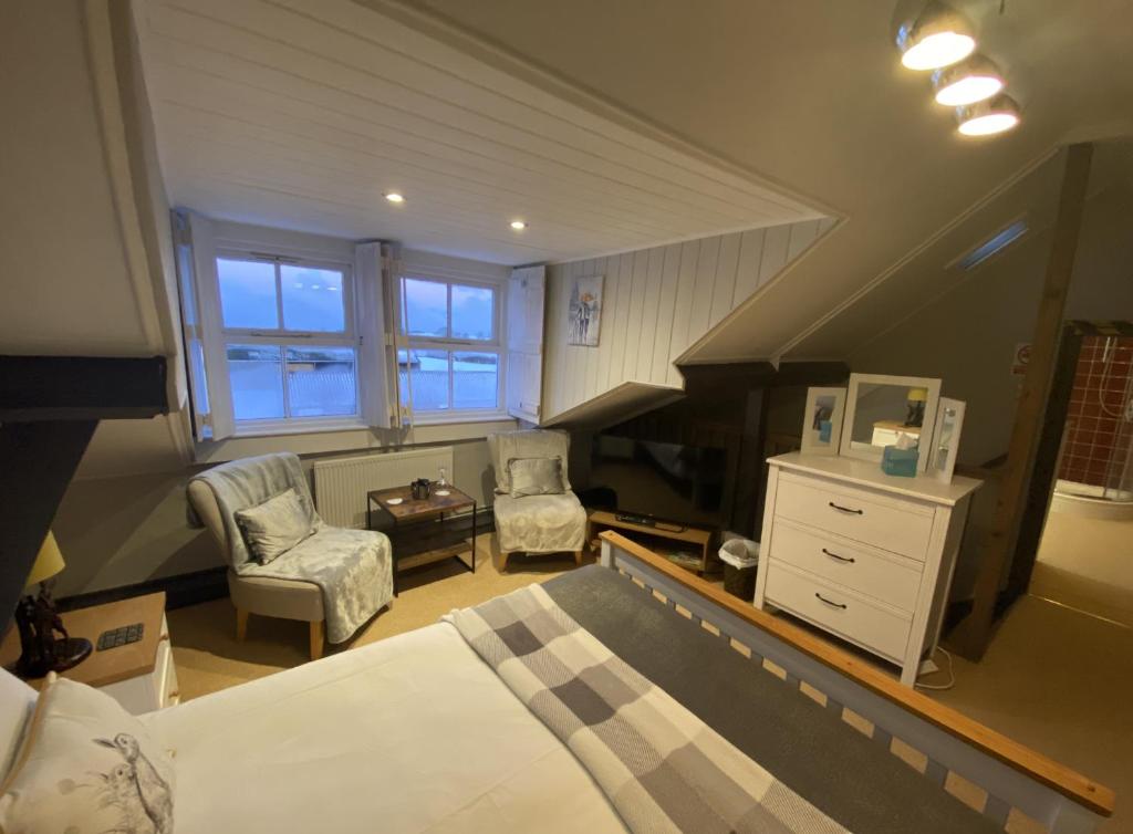 um quarto com uma cama, uma cadeira e um piano em The Foulsyke Licensed Bed and Breakfast Scalby Scarborough em Scarborough