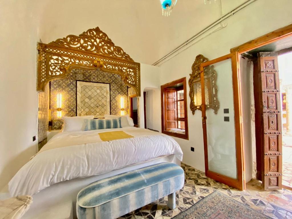 a bedroom with a large bed with a wooden headboard at Suite Noor B&B Pool SidiBouSaid in Sidi Bou Saïd