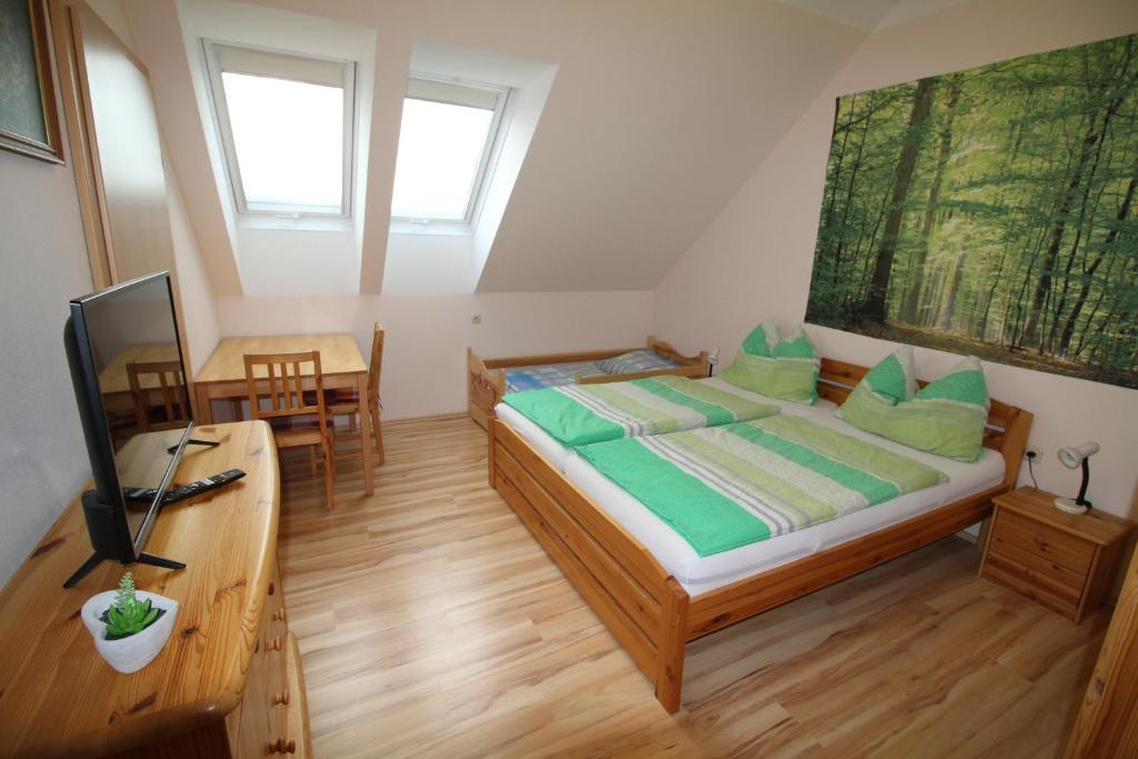 una camera da letto con letto con cuscini verdi e scrivania di Privatzimmer Fam. Führer a Ottenschlag