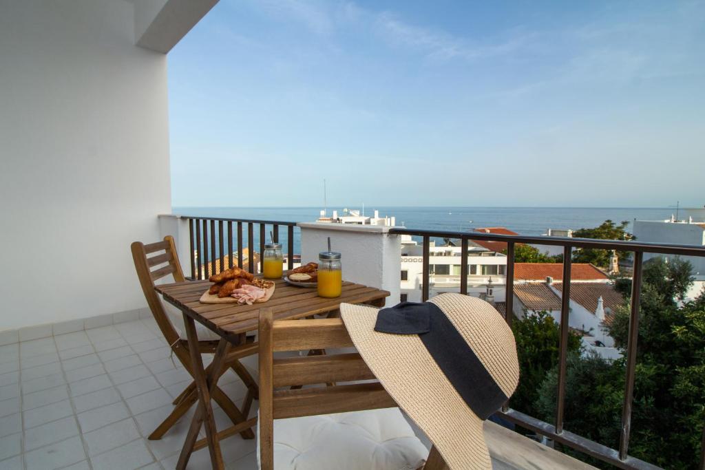 una mesa de madera y sillas en un balcón con vistas al océano en Old Town Apartment NearThe Beach en Albufeira