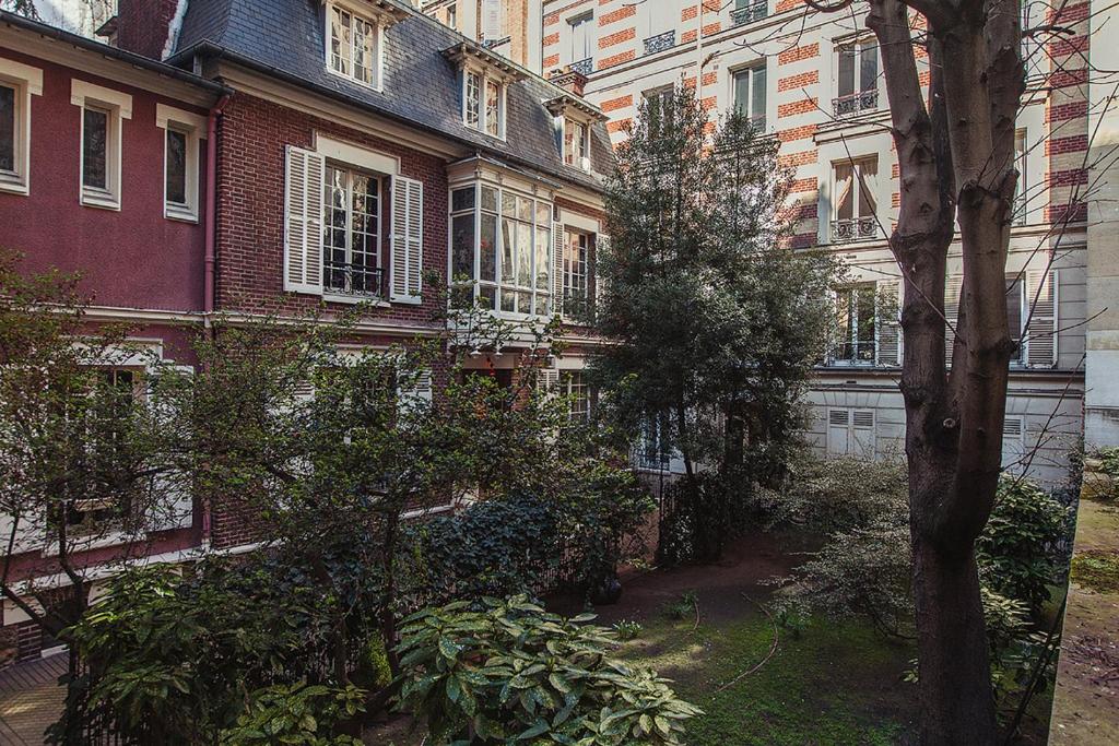 a courtyard in front of a building with trees at Hôtel Particulier - Palais des Congrès in Neuilly-sur-Seine