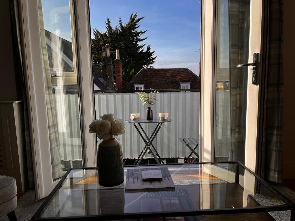 a glass table with a teddy bear sitting on a balcony at Central Windsor, One Bedroom,Terrace & Private Parking in Windsor