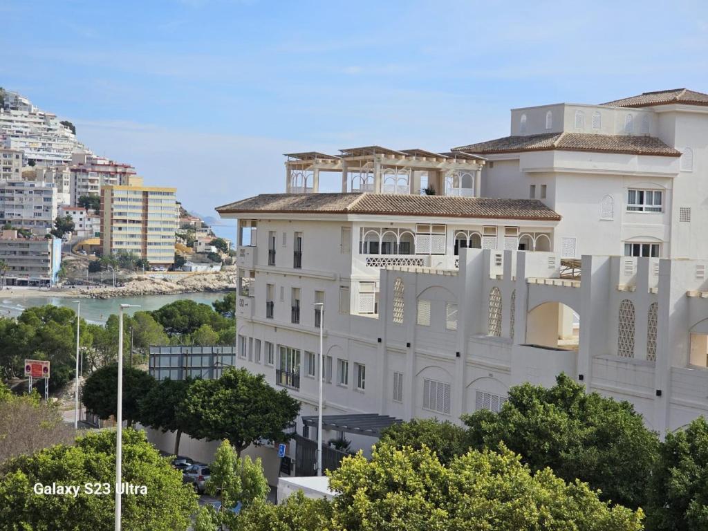 a large white building in front of a city at BENIMAR 2 BEACH VIEW in Cala de Finestrat