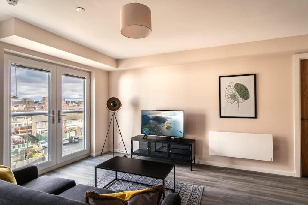 a living room with a couch and a flat screen tv at Modern & Stylish 2 Bed Apartment in Manchester in Manchester
