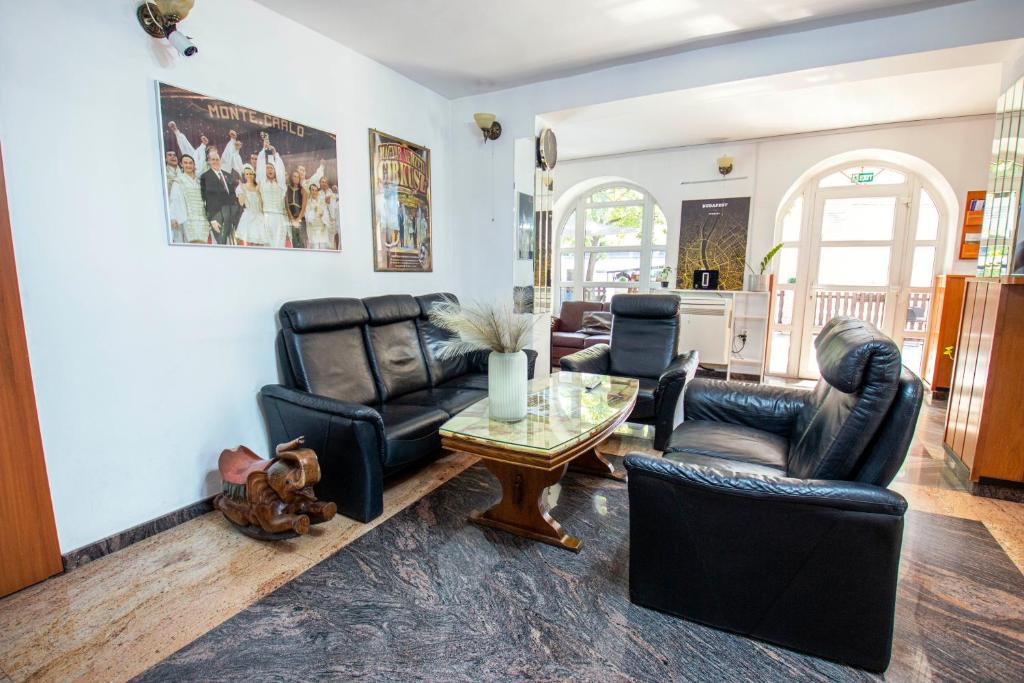 a living room with leather furniture and a table at Richter Pansion in Budapest