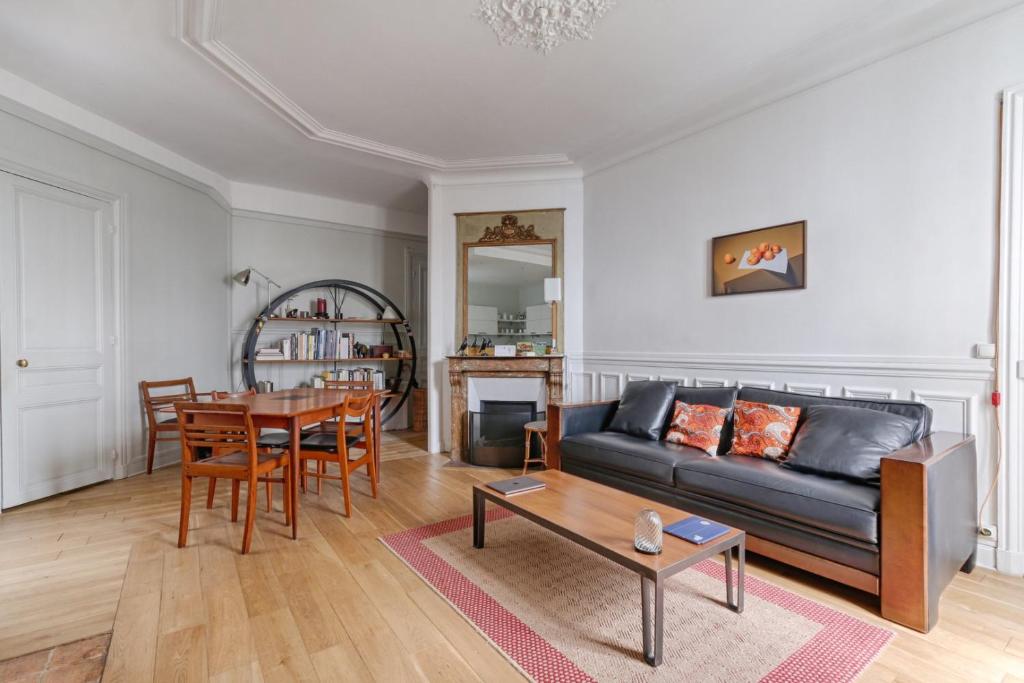 a living room with a couch and a table at Résidor - Haussmanian flat in the heart of Paris in Paris