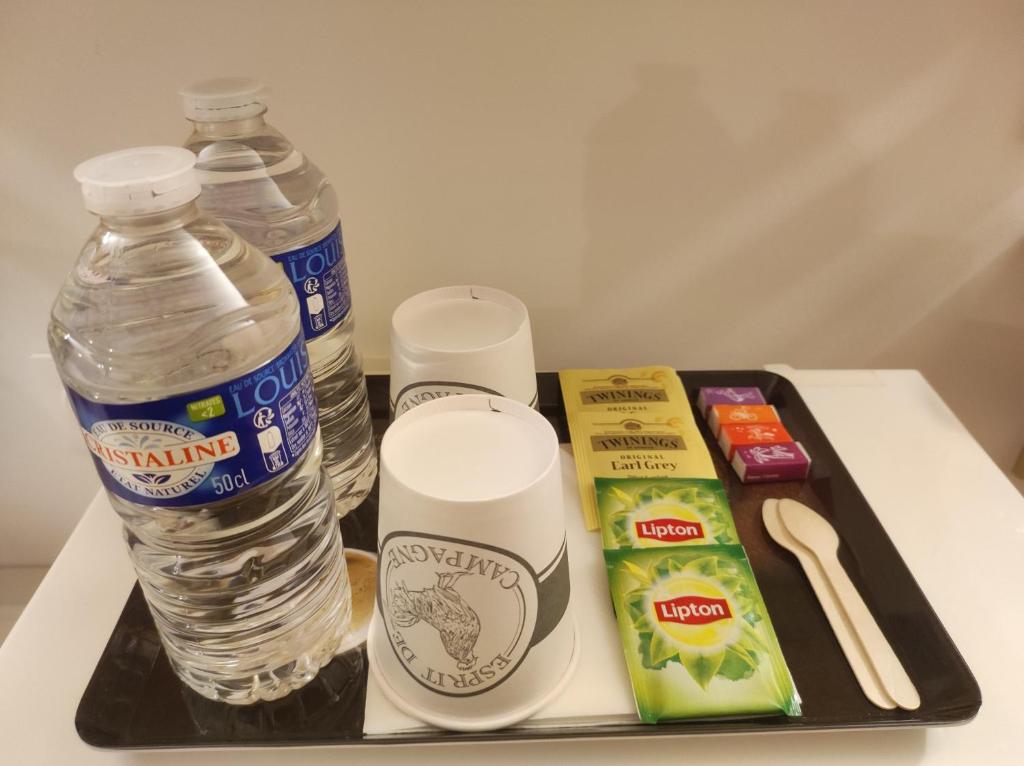 a tray with a bottle of water and some snacks at chalet de Campagne avec option SPA - petit déj 