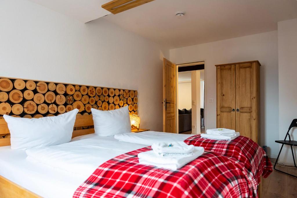 two beds in a bedroom with a red and white blanket at REDWOOD by Tendo Stay - Comfort Housing in Falkensee