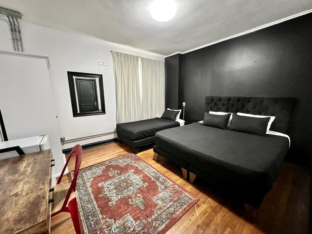 ein Schlafzimmer mit einem Bett, einem Stuhl und einem Sofa in der Unterkunft Hotel Boutique Tremo Bellavista Suite in Santiago