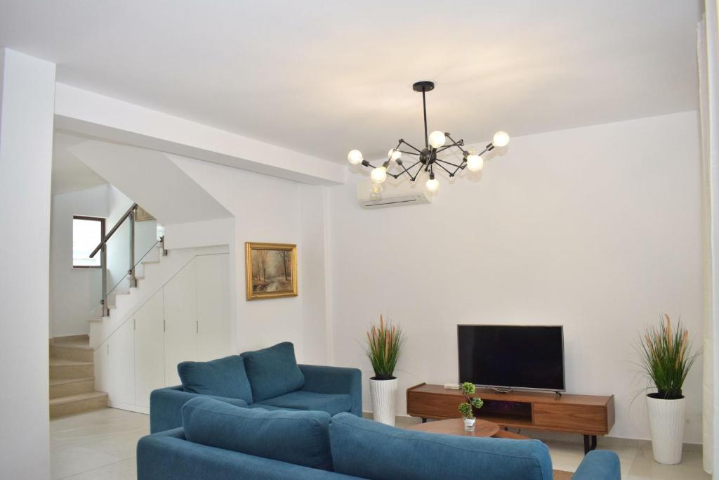 ein Wohnzimmer mit 2 blauen Stühlen und einem TV in der Unterkunft Lalzit Bay Dream Villa - Happy Rentals in Lalzit Bay