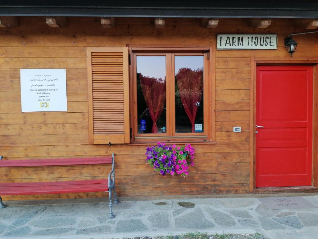 a building with a red door and a bench outside at Casa vacanze in San Fermo della Battaglia