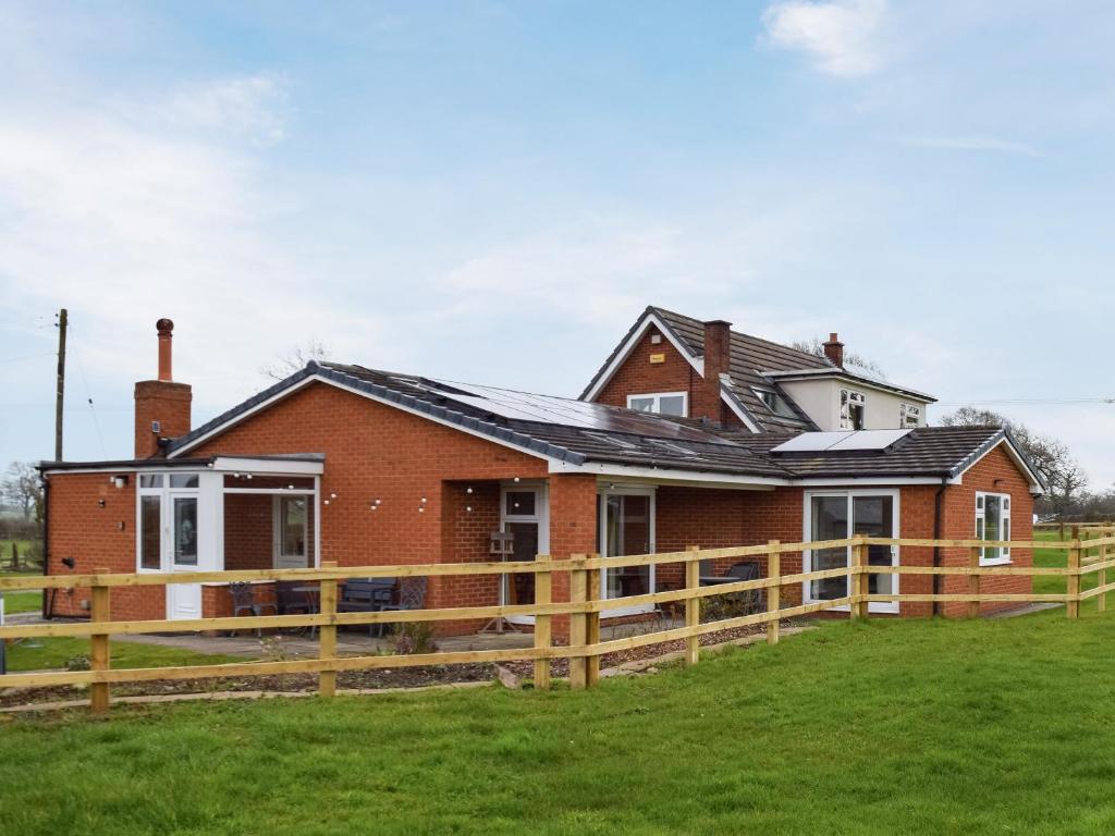 una casa con una valla de madera delante de ella en The Crofts, en Winsford