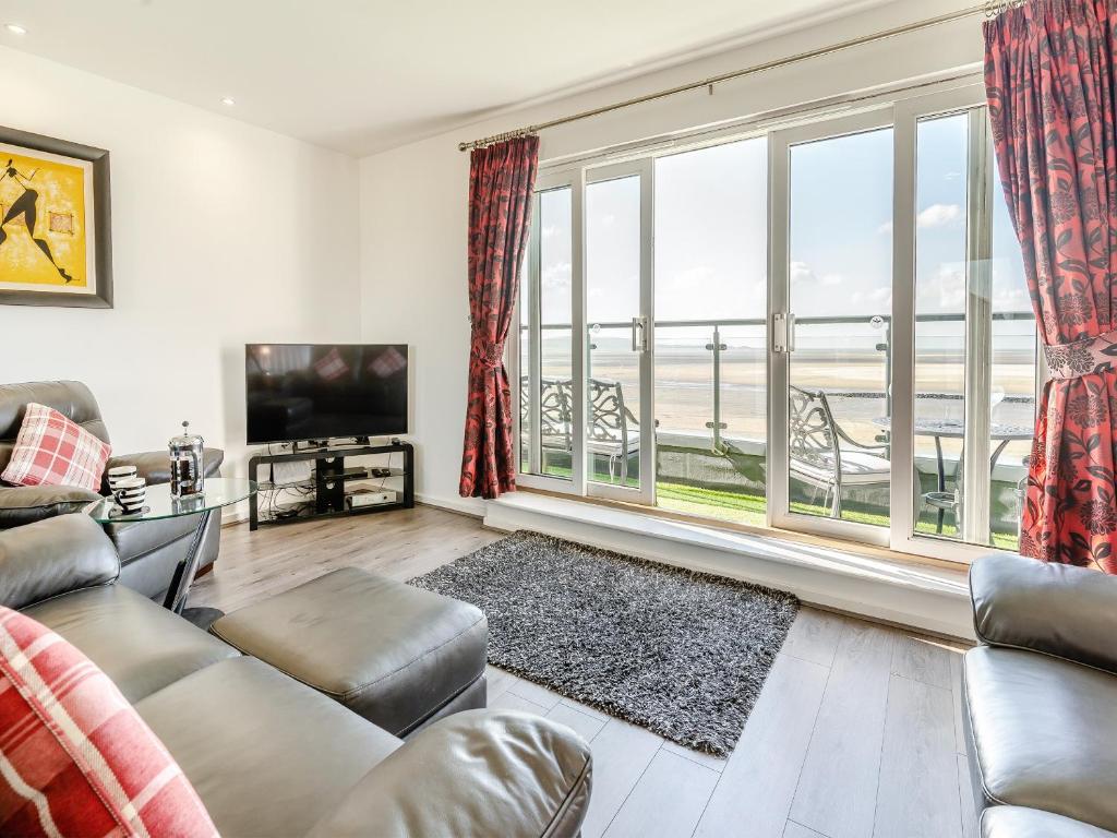 a living room with a couch and a large window at Beachview in Llanelli