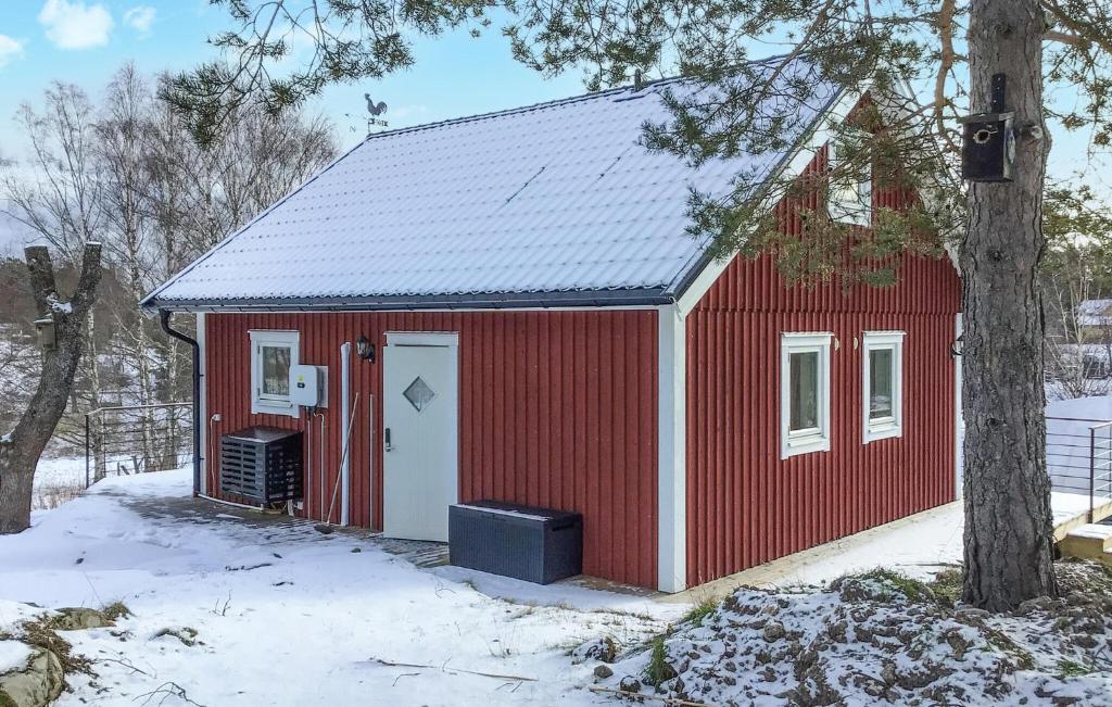 un cobertizo rojo con una puerta blanca en la nieve en Lovely Home In kersberga With Wifi, en Åkersberga