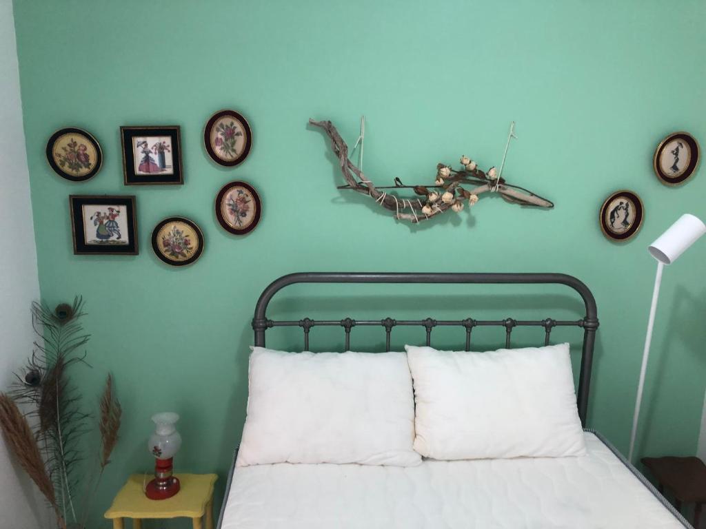 - une chambre dotée d'un mur bleu avec un lit et des réveils encadrés dans l'établissement Terrace house, à Siteía