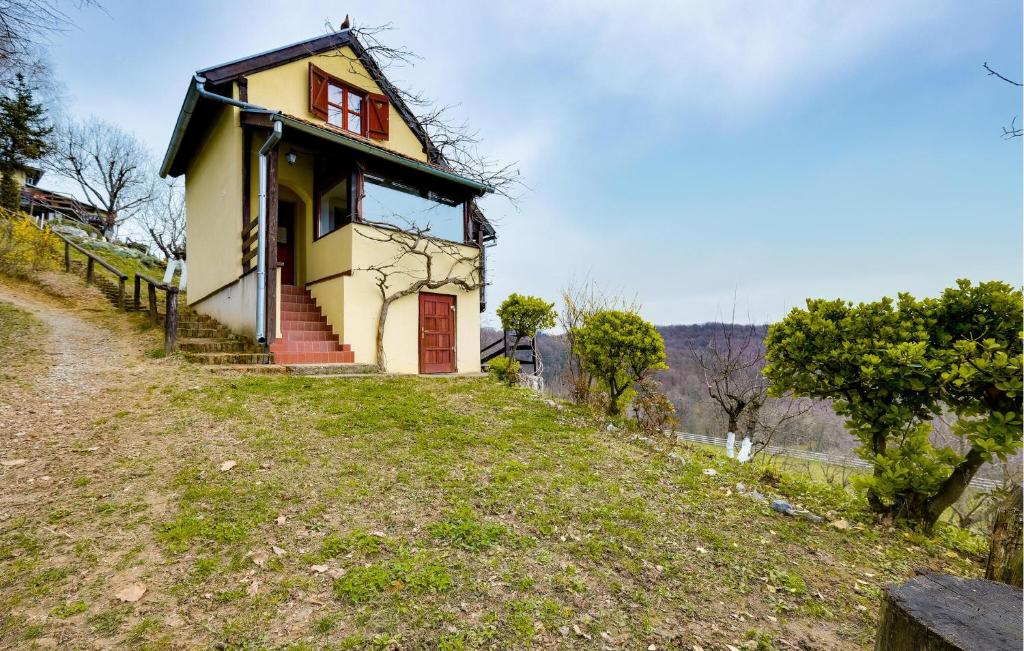 una pequeña casa al lado de una colina en Nice Home In Veliki Grdevac With Kitchen 