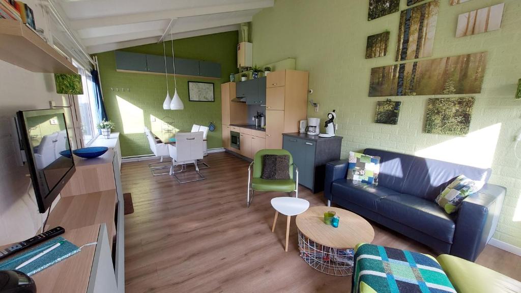 a living room with a blue couch and a kitchen at Vakantiehuis Saffier in Simpelveld