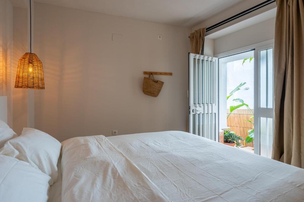 una camera con un letto bianco e una finestra di I AM Benalmádena a Benalmádena