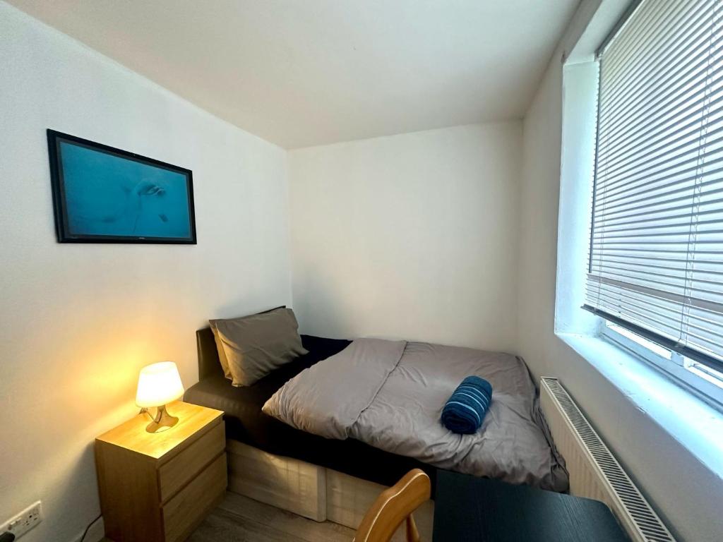 a small bedroom with a bed and a window at Bethnal Green Rooms R2 in London