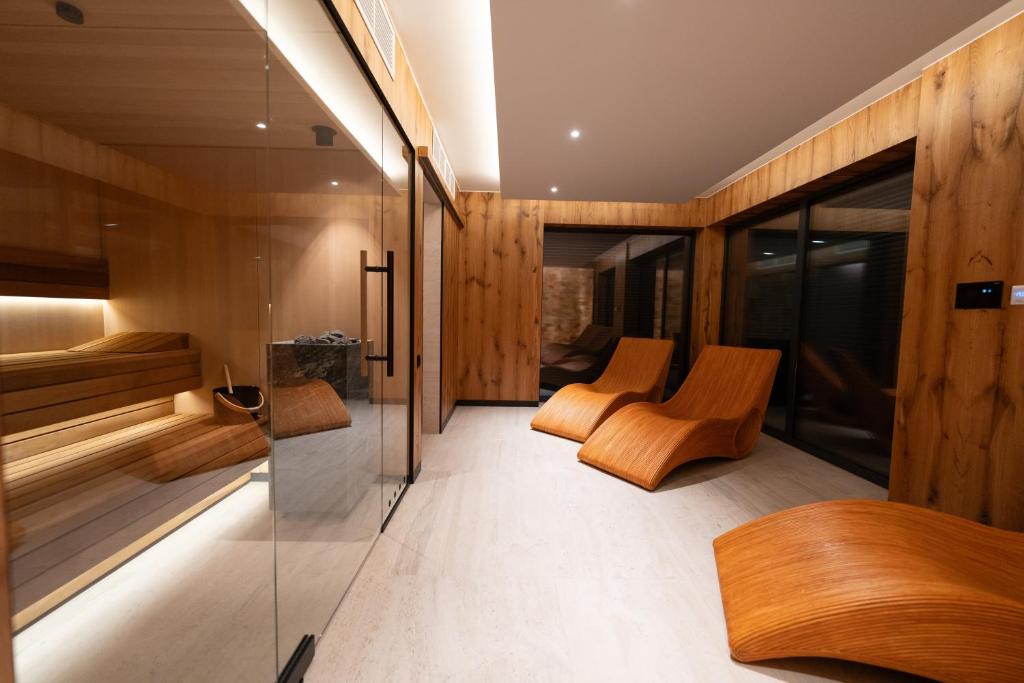 Habitación con paredes y sillas de madera y pared de cristal. en Apartamenty Pod Gondolą - Mountain Resort Villa z sauną - Dream Apart en Szczyrk