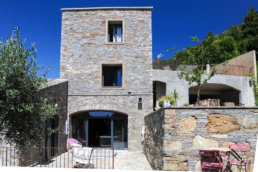 a large stone building with a stone wall at Jolie maison avec piscine près d'un village typique in Monte