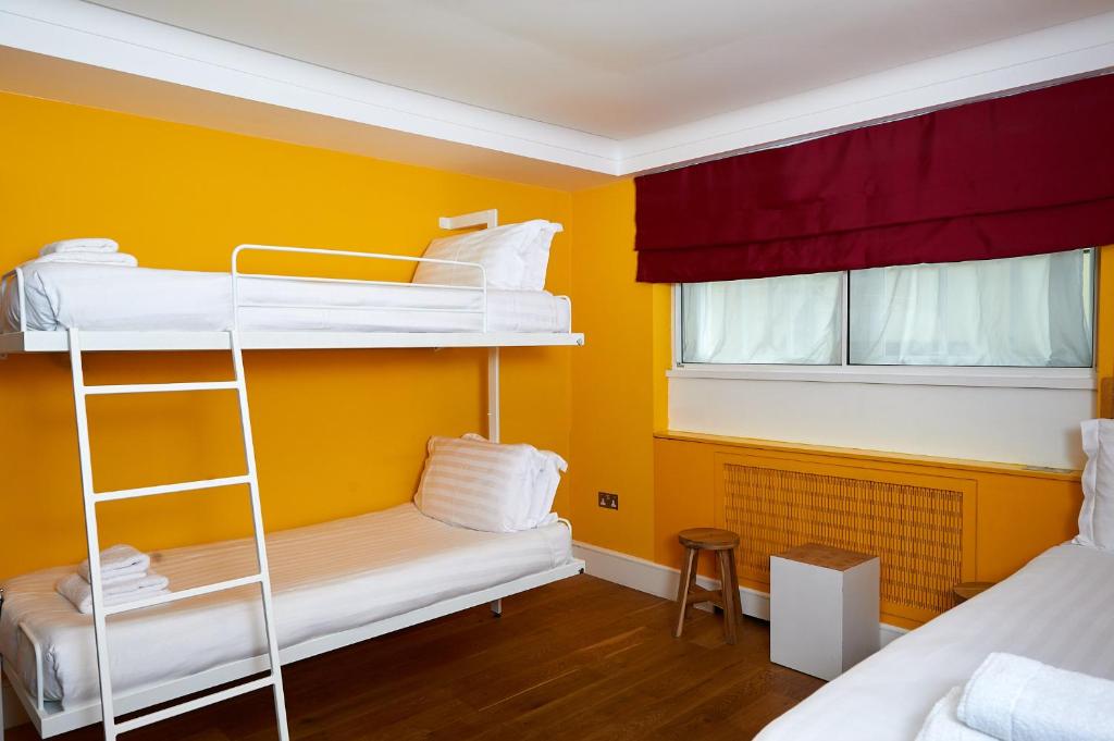a room with two bunk beds and a window at The California - London Kings Cross in London