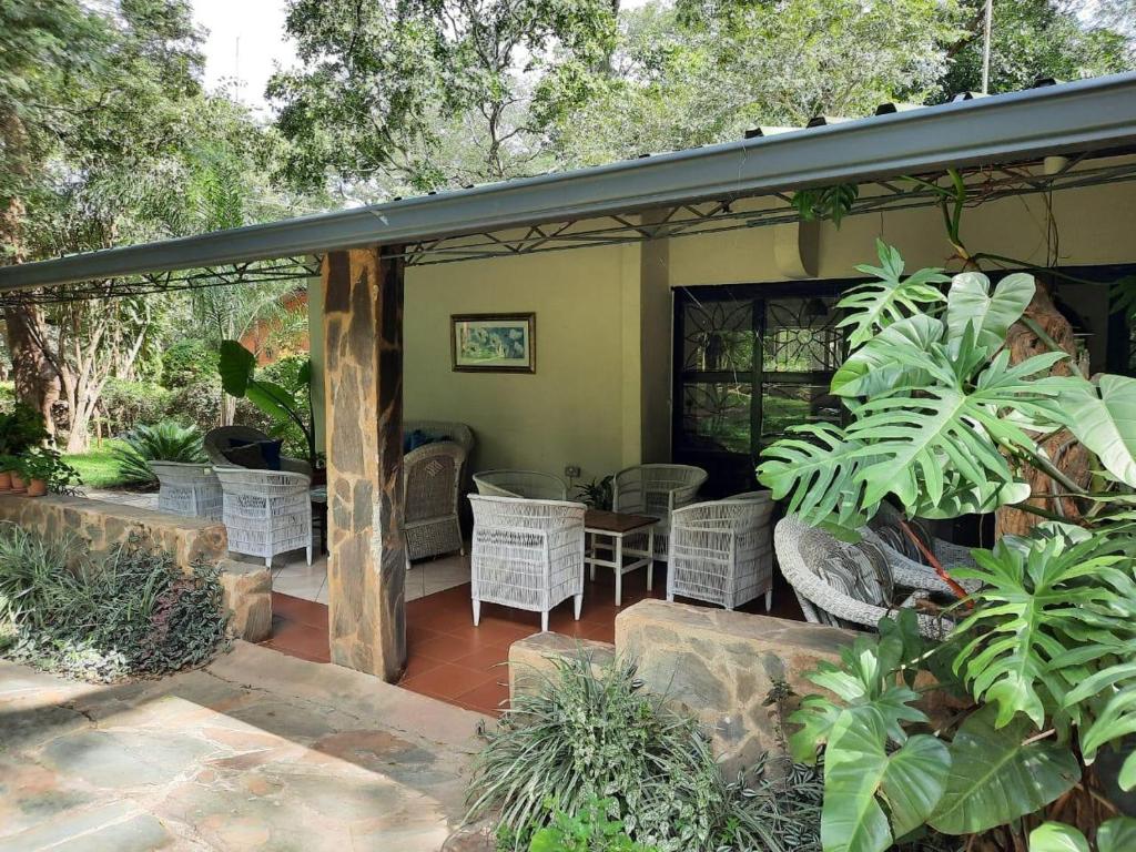 d'une terrasse couverte avec des chaises en osier et une table. dans l'établissement Fika Lodge, à Mkushi