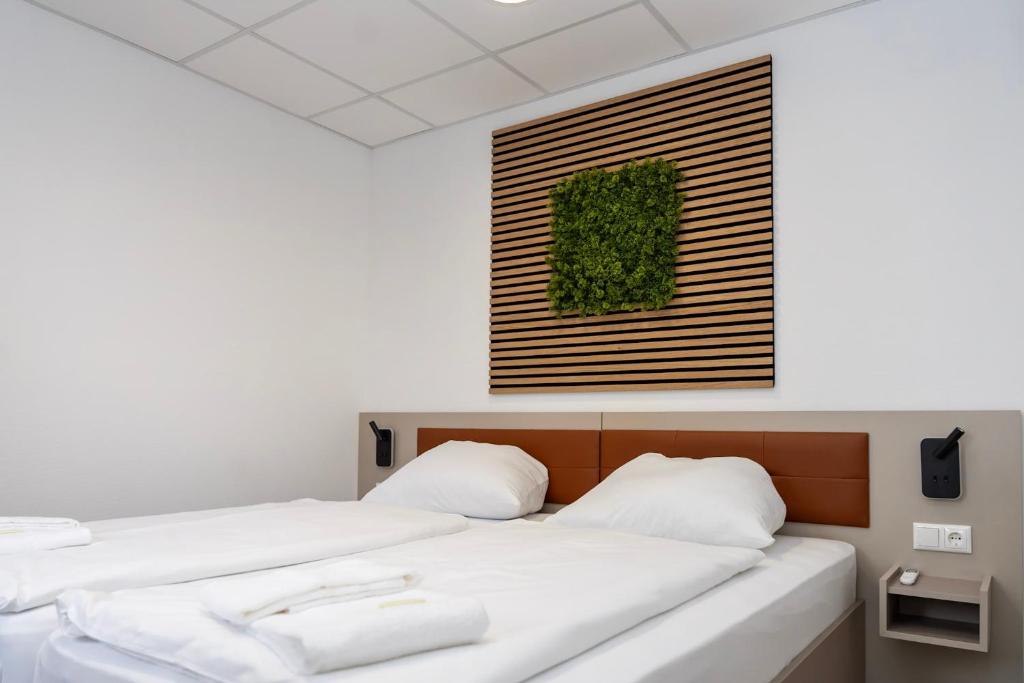 2 camas en una habitación con una foto en la pared en Comfort Housing Apartments en Falkensee