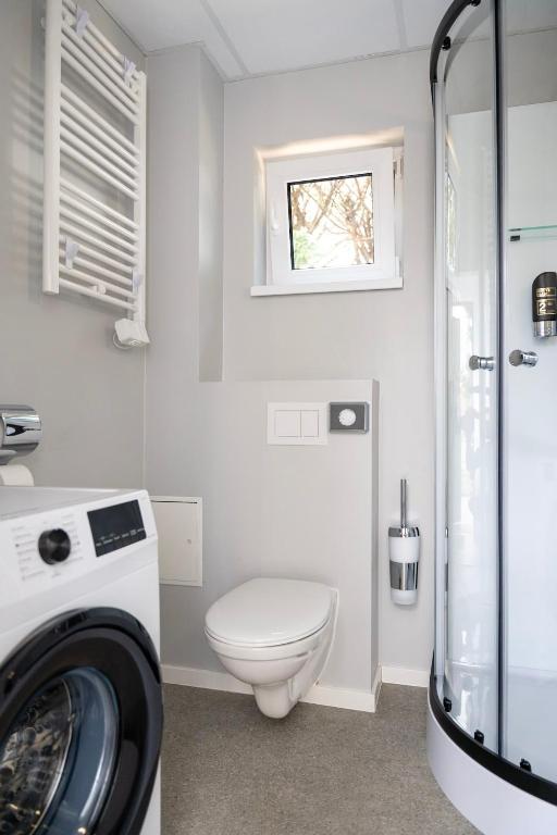 ein Badezimmer mit einem WC und einer Waschmaschine in der Unterkunft Comfort Housing Apartments in Falkensee