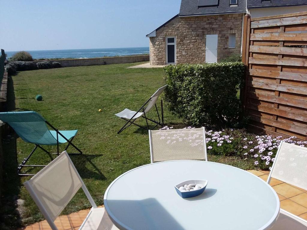 - une table blanche avec des chaises et un bol sur le dessus dans l'établissement Maison 3 pièces avec Terrasse et Garage, proche centre de Quiberon - FR-1-478-117, à Quiberon