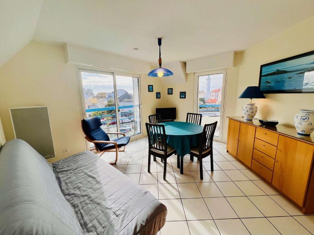 un salon avec une table, des chaises et une télévision dans l'établissement Quiberon: Charmant T3 avec terrasse, 20m de la plage, parking, animaux acceptés - FR-1-478-29, à Quiberon