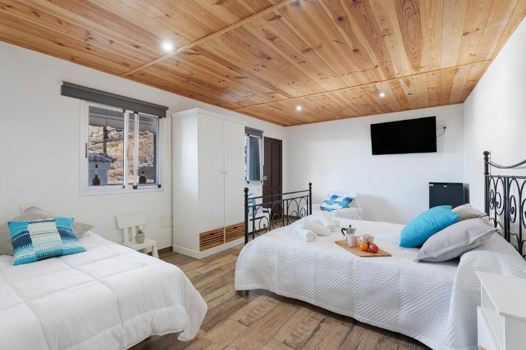 two beds in a bedroom with a wooden ceiling at Casa Nene in La Matanza de Acentejo