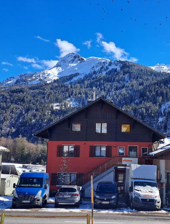 a building with cars parked in a parking lot with a mountain at Ferienwohnung Pia in Wald am Arlberg