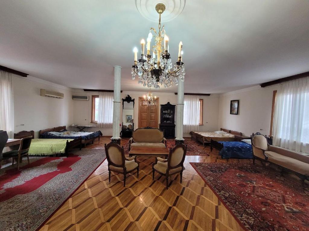 uma ampla sala de estar com um lustre e um sofá em Гостевой дом ЧАЙКА em Kobuleti