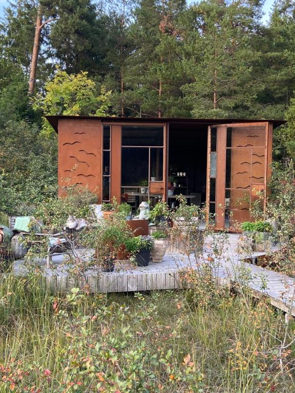 une petite maison avec des plantes devant elle dans l'établissement Maven Kustnära Stugor, à Kappelshamn