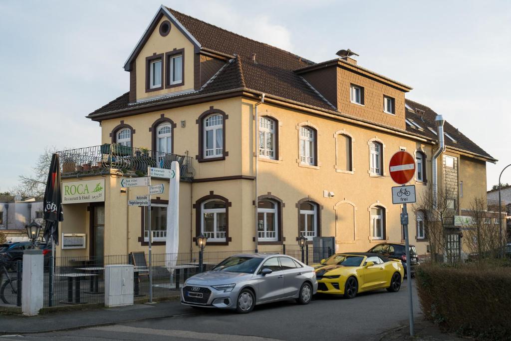 dois carros estacionados em frente a um edifício em Roca Restaurant und Hotel em Bommersheim
