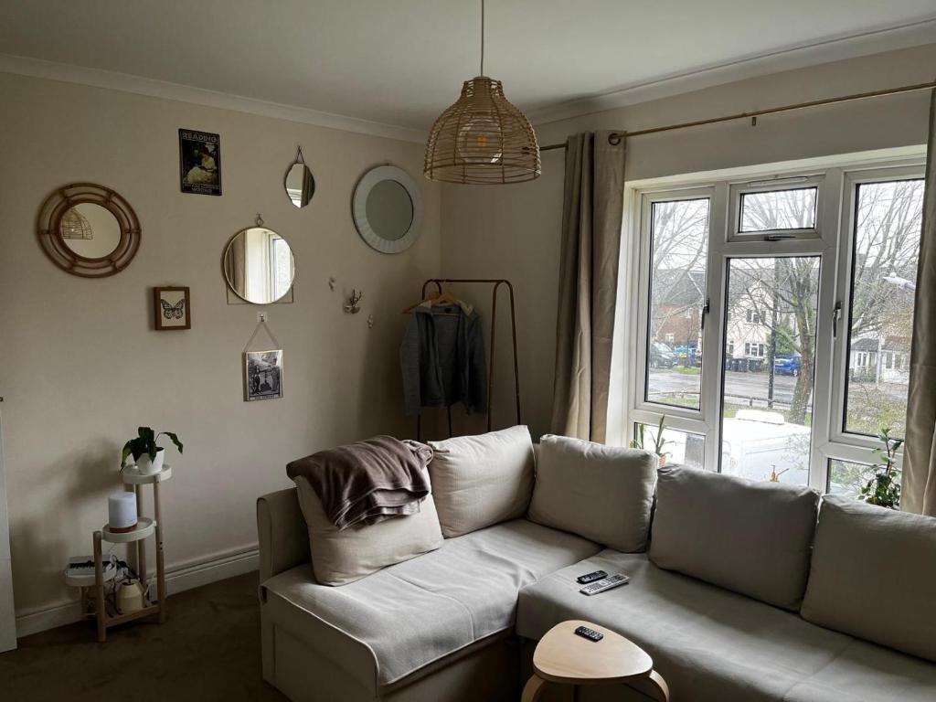 a living room with a couch and a window at Single room in shared flat Valley Hill, Loughton in Loughton