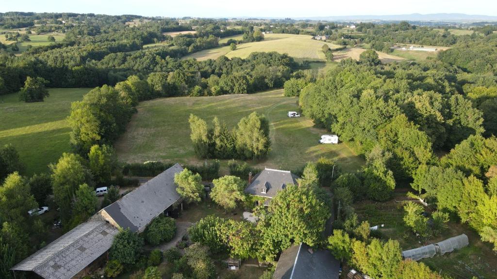 an aerial view of a house in a field with trees at wooden cabin in nature in Troche