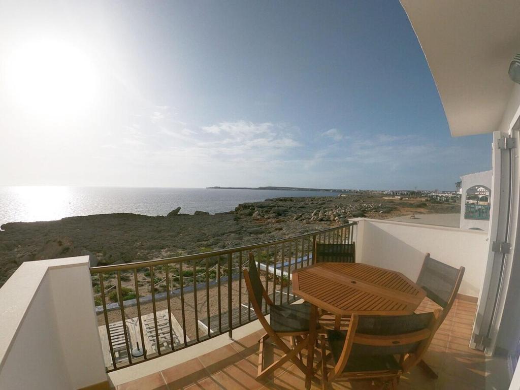 einen Balkon mit einem Tisch, Stühlen und Meerblick in der Unterkunft Piso en primera linea de mar - CA NA NÚRIA in Cala Blanca