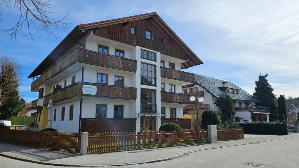 duży biały budynek z drewnianym dachem w obiekcie Hotel Pension Geiger w mieście Bad Tölz
