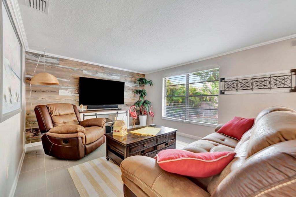 a living room with a couch and chairs and a television at Tarpon Springs Family Vacation 5 mins to beach in Tarpon Springs