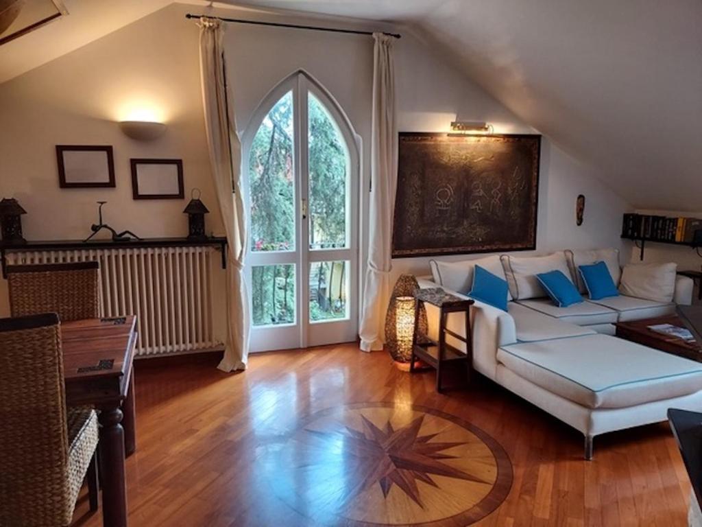 ein Wohnzimmer mit einem weißen Sofa und einem großen Fenster in der Unterkunft Casa della Elli in Santa Margherita Ligure