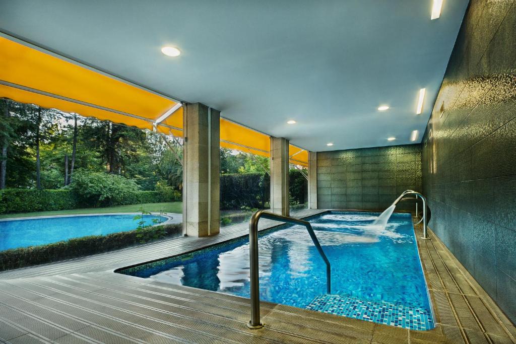 einen Pool in einem Haus mit einem Schwimmpoolvisor in der Unterkunft Hotel Grao Vasco in Viseu