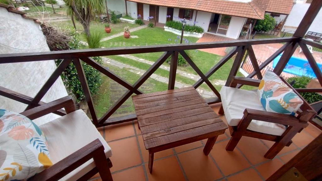 a balcony with two chairs and a table and a bench at Palmeras Appart Hotel in Chascomús