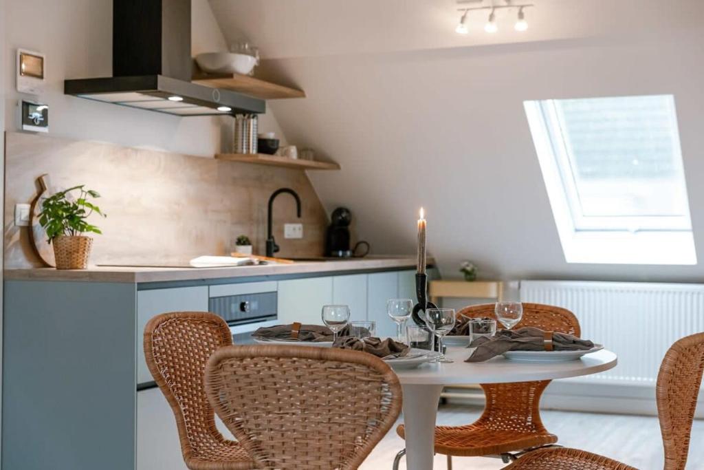 a kitchen with a table and chairs with wine glasses at Bright apartment close to the sea in Ostend